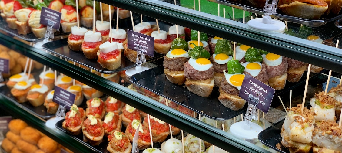 A display counter filled with various tapas and pintxos